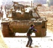 Boy in Palestine throws rock at tank