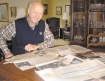 Tallgrass Creek resident and former FBI agent Jim Graham reviews the many newspaper clippings his wife, Marlene, saved that outlined his career. (Photo by Mary Bush)