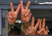 Palestinian in handcuffs makes peace sign