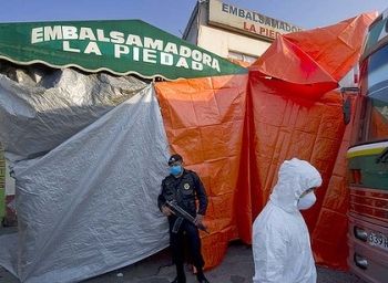 Soldiers guard emergency morgue erected to house bodies from the mass graves discovered.