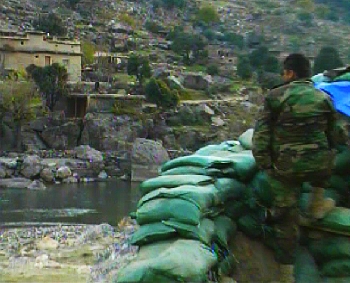 A soldier from Afghanistan stares across the Pakistan border, this is where all of the attacks come from in the Pesh Valley. 