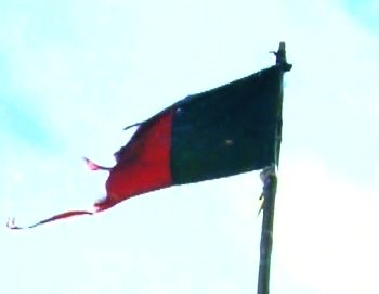 Tattered Afghan flag flying in the Pesh Valley