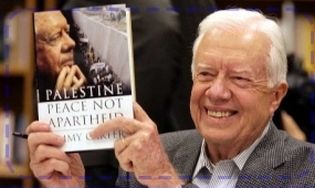 Former U.S. President James Carter holds his book up at a book sogning 12 Dec. 2006